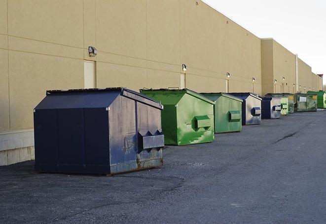 construction workers throw waste into a dumpster behind a building in Blue Island